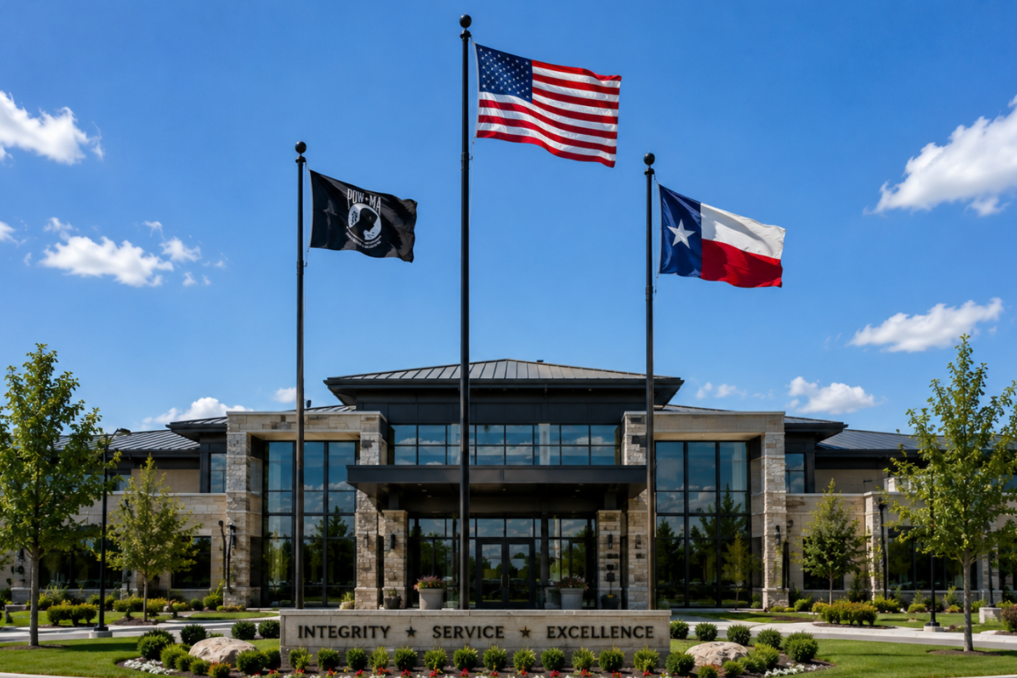 Building exterior with flags and 'Integrity Service Excellence' sign against a blue sky.