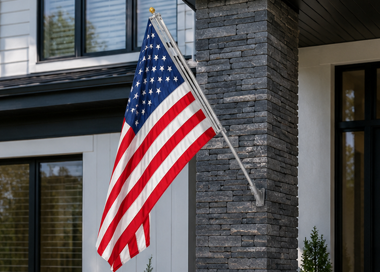 American flag on a flagpole in front of a house with stone columns.